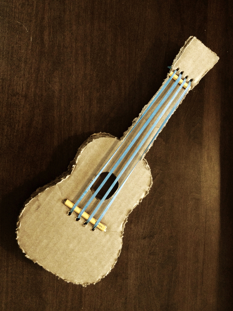 Acima e abaixo temos duas opções de violão que podem ser feitos com papelão. Utilizando linha de pesca ou elástico é possível criar um brinquedo que realmente emita sons!