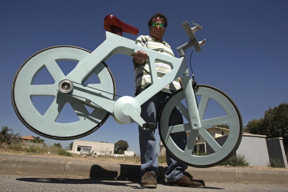 Israeli inventor Izhar Gafni holds his cardboard bicycle in Ahituv