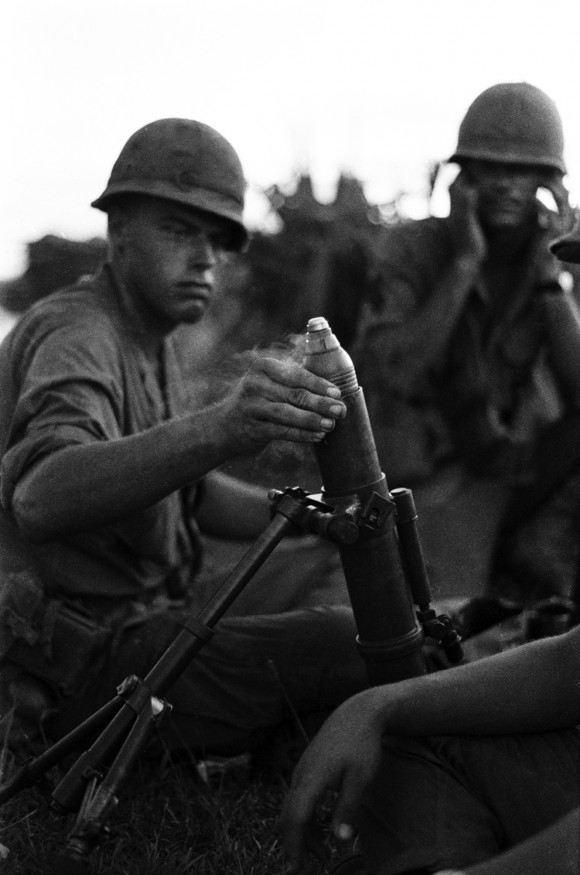 Soldados dispara um morteiro 60 milímetros M2 capturado, originalmente uma arma produzido pelos Estados Unidos para uso na Segunda Guerra Mundial e na Guerra da Coreia. O morteiro foi capturado em uma patrulha em uma plantação de arroz, das forças vietcongues. Nomes, data e local desconhecidos.