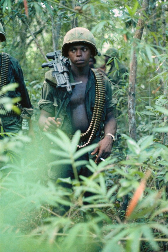 Um, jovem M60 operador de metralhadora de alerta na selva. Nomes, data e local desconhecidos.