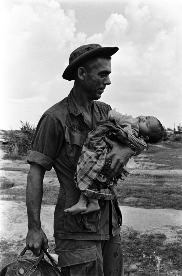Sargento Edgar D. Bledsoe, de Olive Branch, Illinois, embala um bebê vietnamita gravemente doente. A criança foi levada a base de apoio. Esta imagem foi originalmente publicado no vol. 3 N º 53 da revista Tropic Lightning News, 30 de dezembro de 1968.