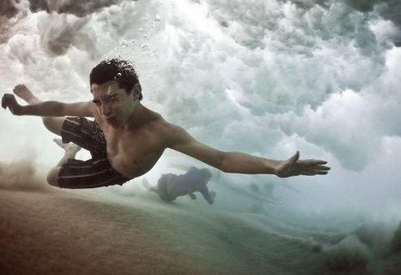 Surfistas abaixo de onda. Foto por: Mark Tipple