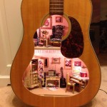Casa de bonecas dentro de um violão