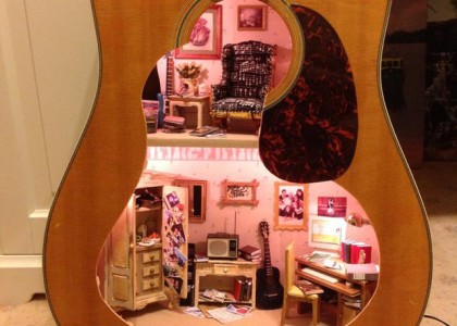 Casa de bonecas dentro de um violão