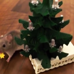 Veja um rato treinado enfeitando uma pequena árvore de natal